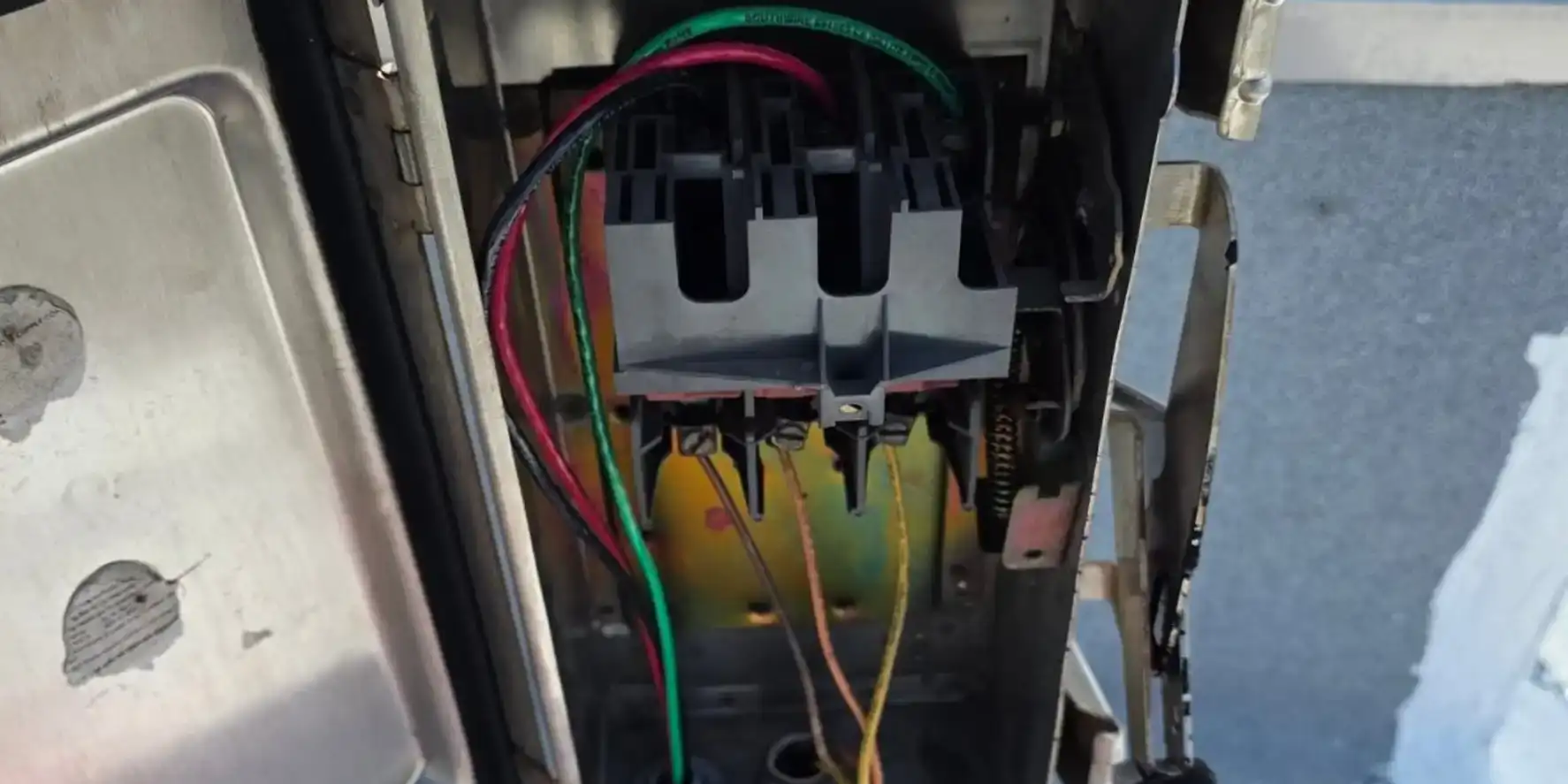 Open AC disconnect box beside a rooftop condenser showing the pull block and line wiring on a Liberty Air and Electric electrical service call.