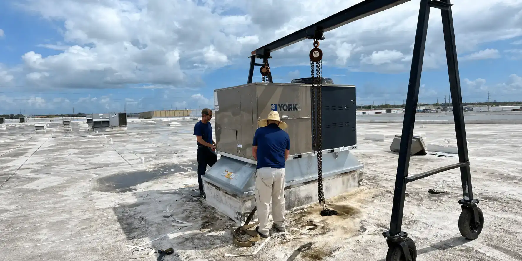 AC techs installing a packaged HVAC unit.