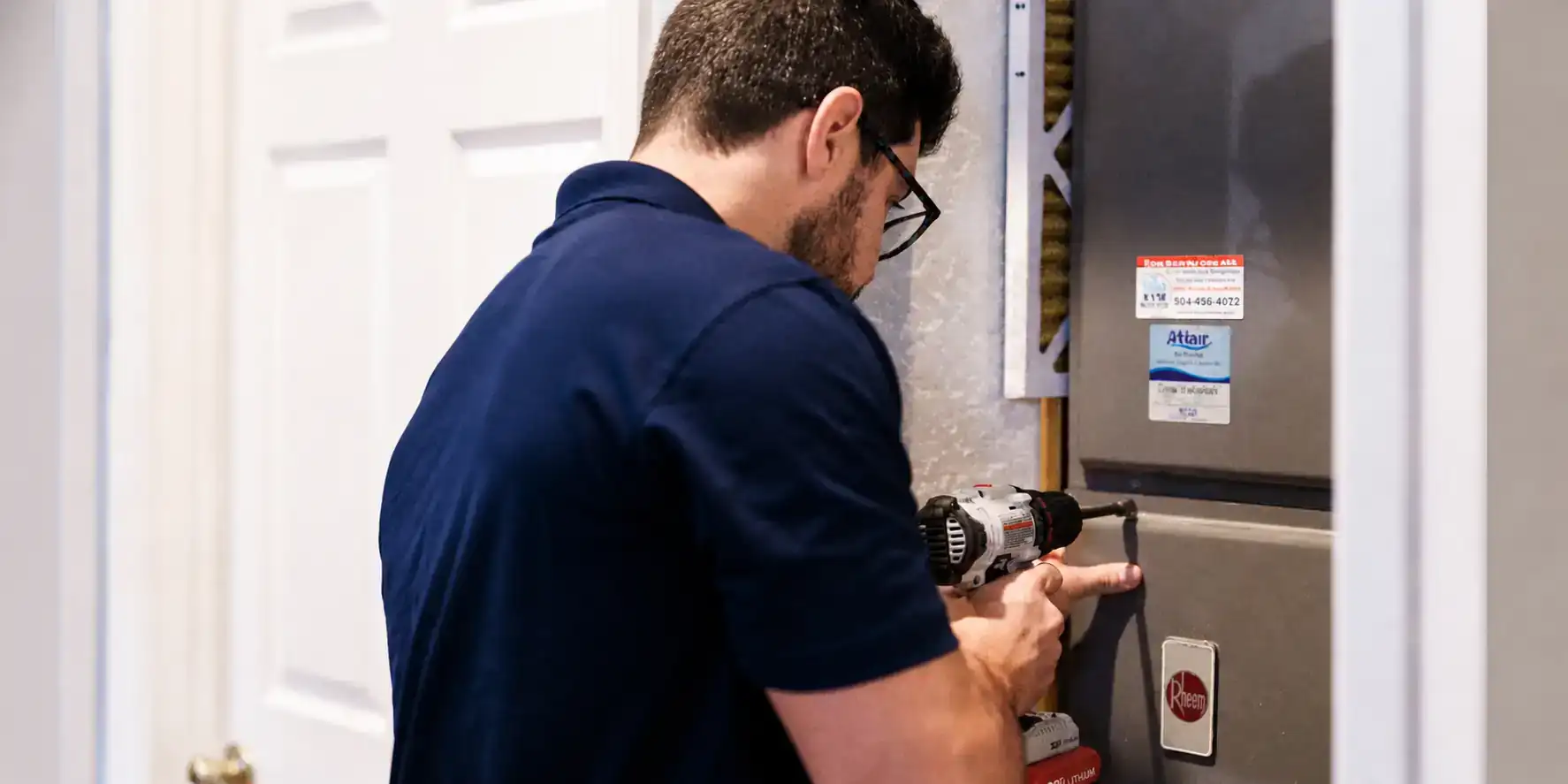 AC tech inspecting an indoor air handler.