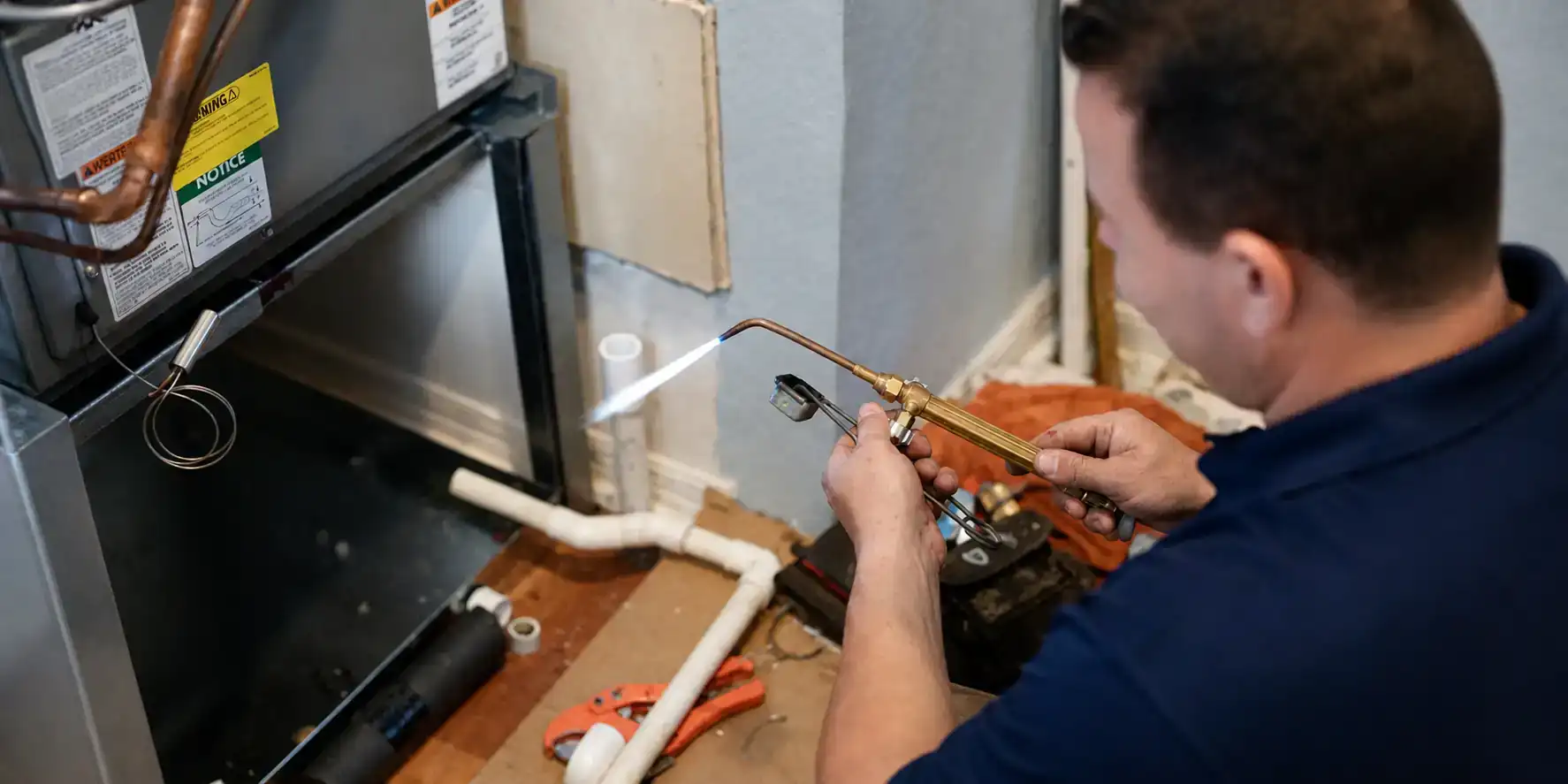AC tech brazing an evaporator coil during a repair.