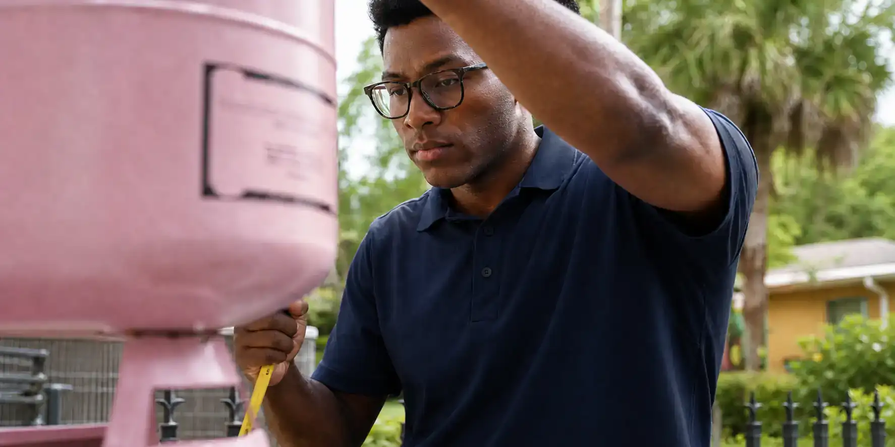 AC tech inspecting an AC unit with a gauge set.
