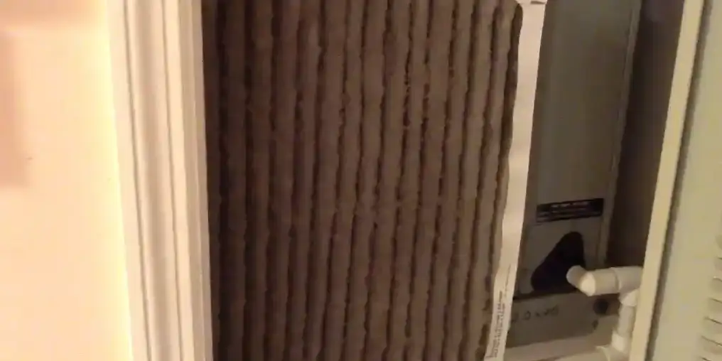 A return-grille air filter packed solid with grey dust beside a Florida air handler.