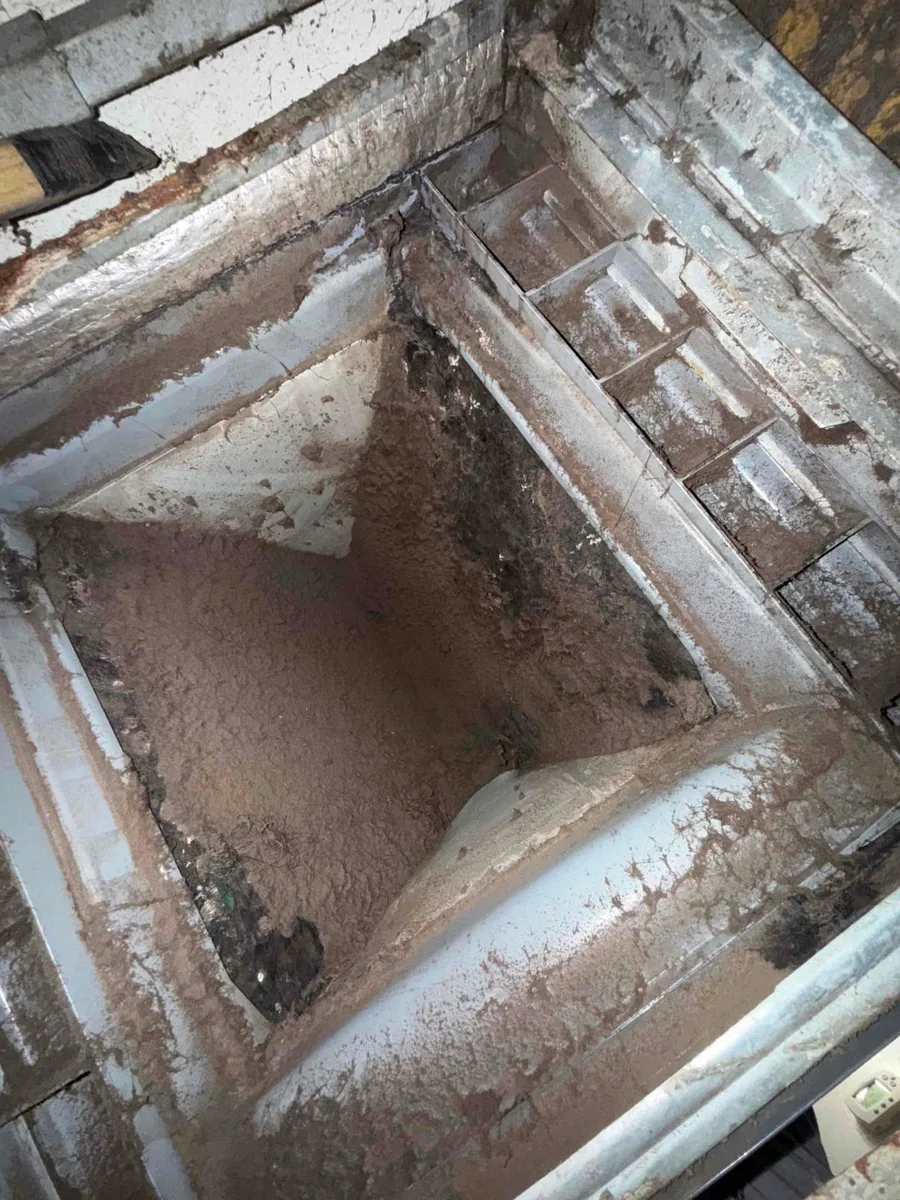 Inside of a return box caked with dust on a Liberty Air and Electric job, where the system had run without a proper filter.