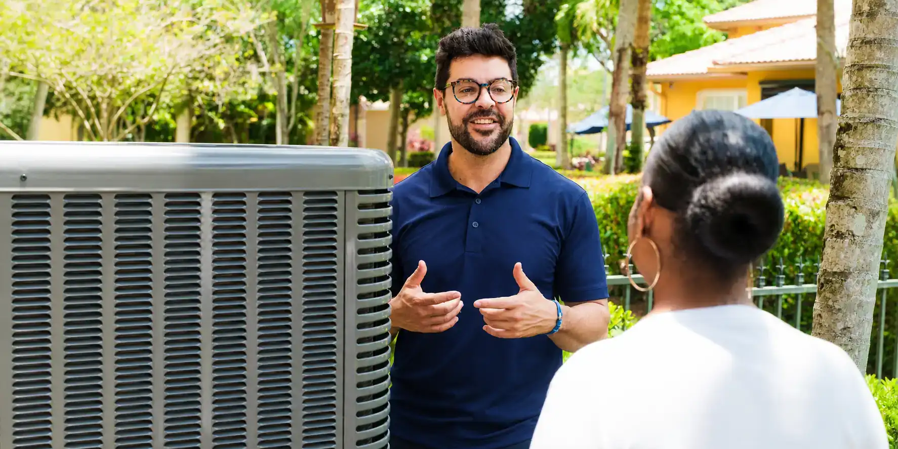AC tech discussing maintenance options with a homeowner.