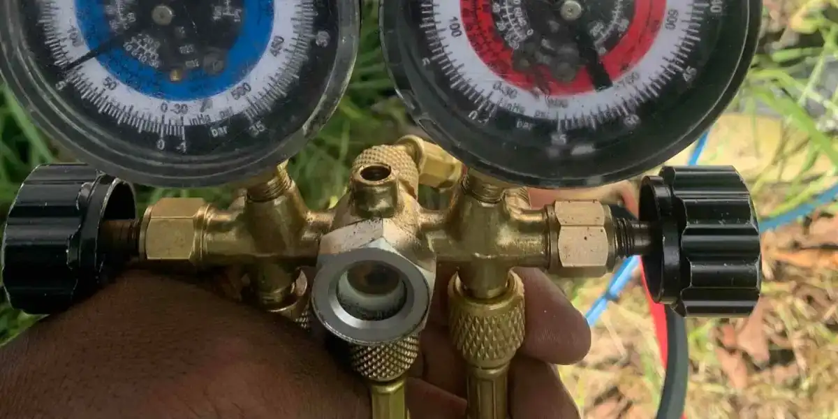 Liberty Air and Electric tech reading manifold gauges on a Florida AC system running low on refrigerant.