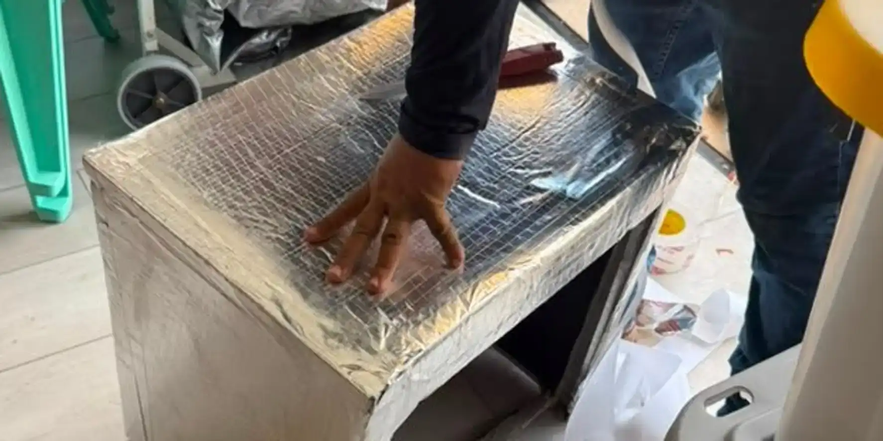 AC tech setting a custom-fabricated insulated sheet metal plenum on a residential job.