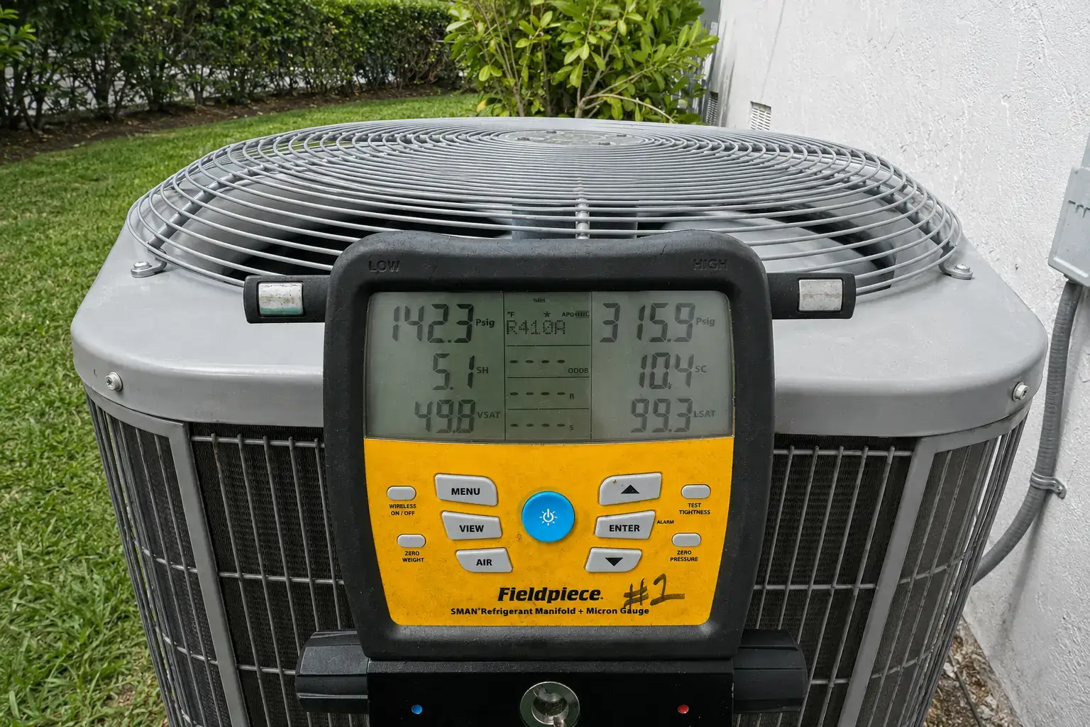 Fieldpiece SMAN refrigerant manifold gauge showing R-410A pressures (142.3 PSIG low side, 315.9 PSIG high side) during a residential AC diagnostic in Florida.