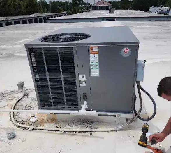 Liberty Air and Electric tech servicing a Rheem Classic series package unit on a Florida rooftop install.