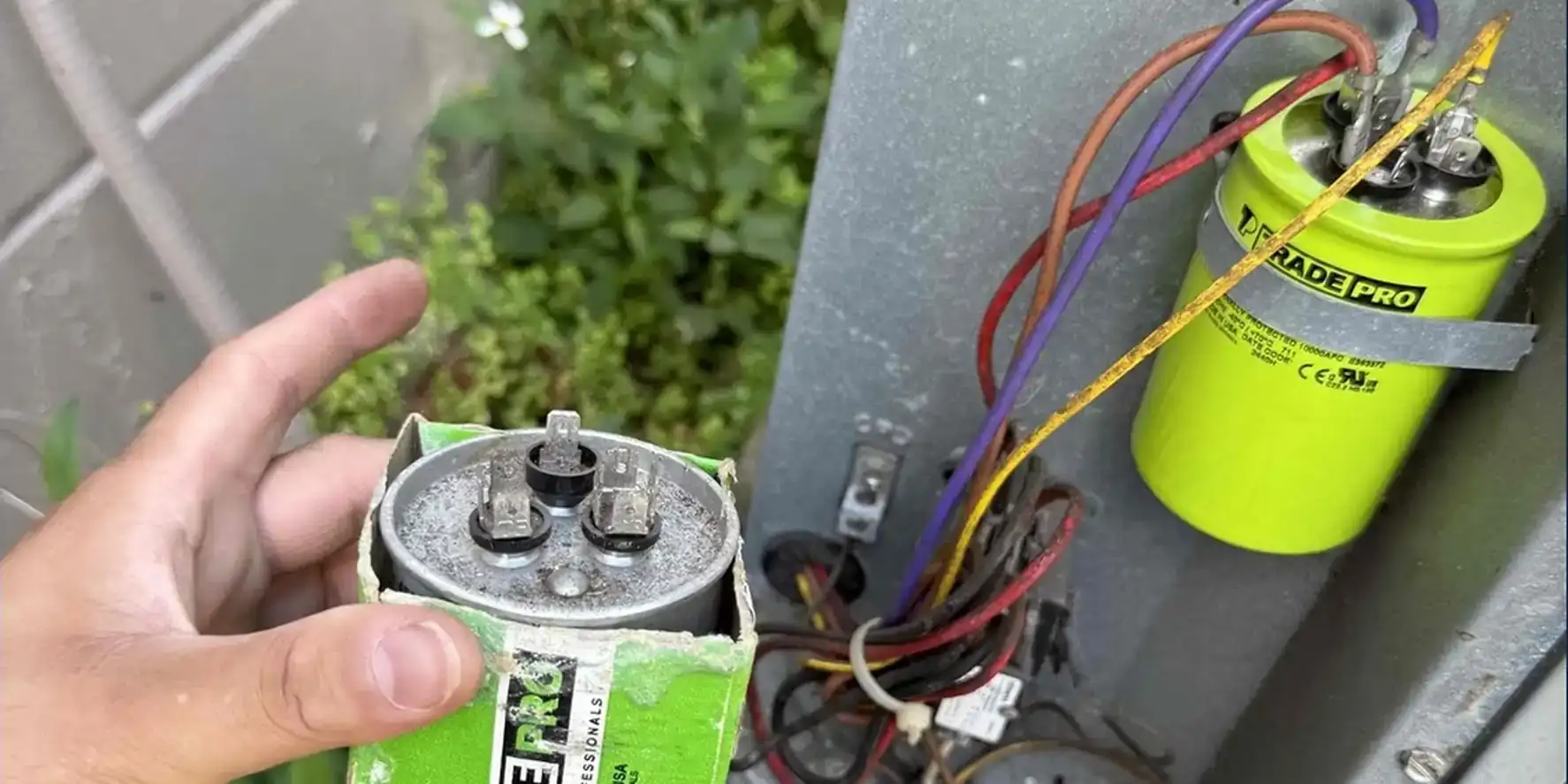 Old run capacitor boxed up next to the new capacitor strapped into the condenser cabinet on a Liberty Air and Electric repair call.