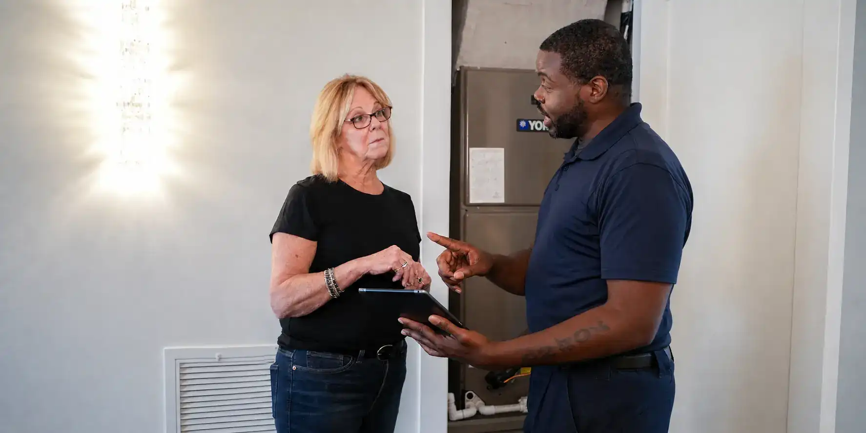 Liberty Air and Electric tech walking a homeowner through a service quote on a tablet.