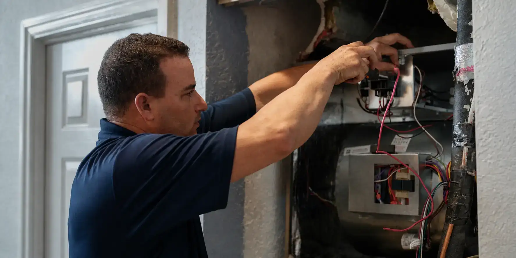 Liberty Air and Electric tech wiring the control board on a newly installed air handler in a Wedgefield home.
