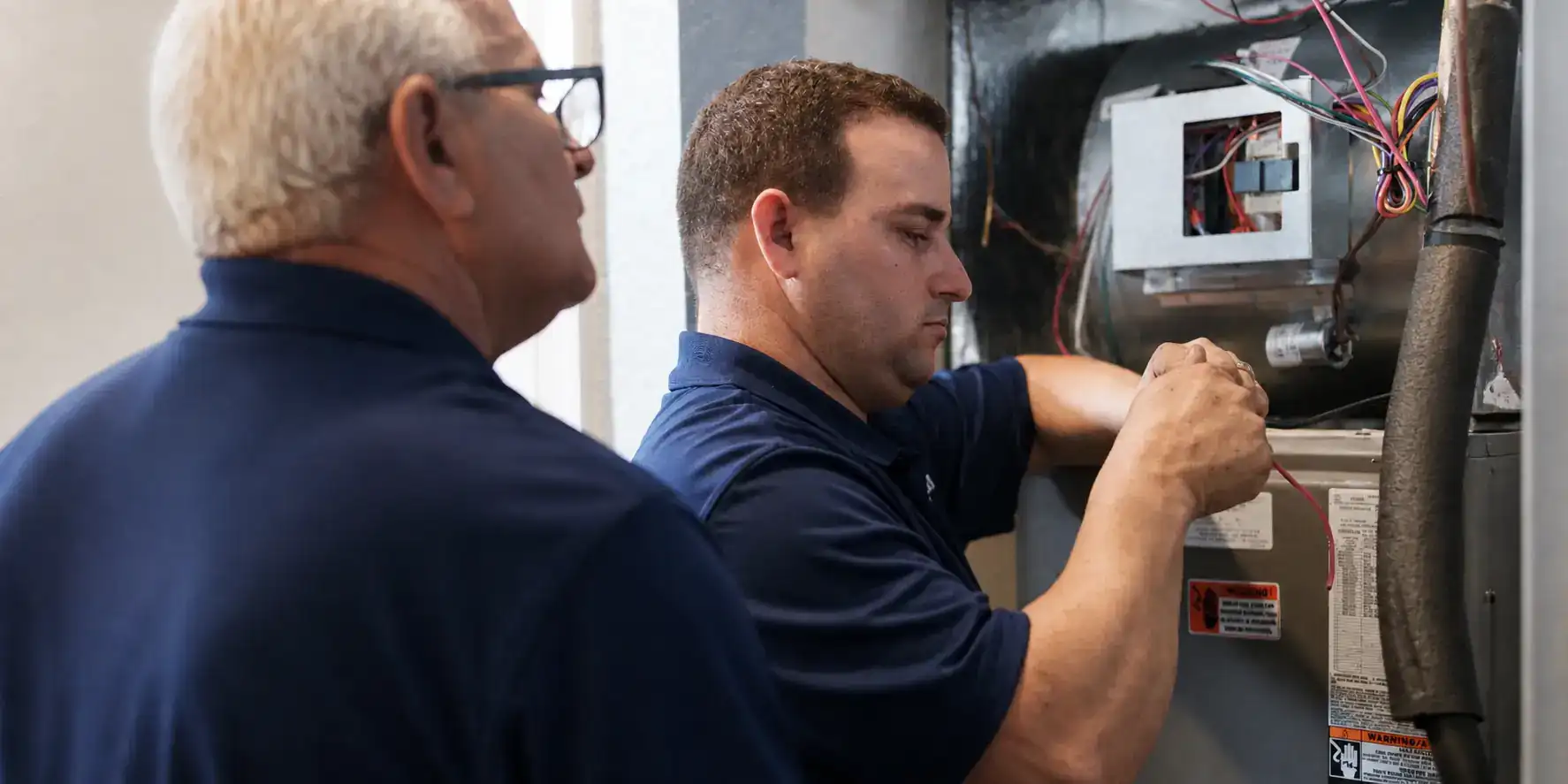 Two Liberty Air and Electric techs working together on an air handler in Florida.